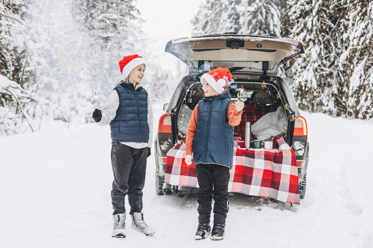 Kids in Santa hats by SUV decorated for Christmas, winter picnic scene. Top SUVs to Rent in Dubai – Headway Rent A Car.